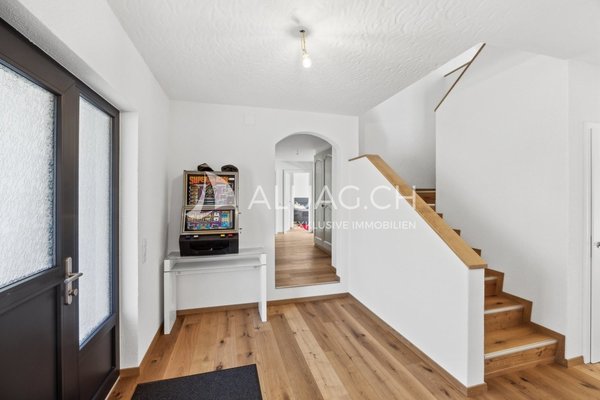 Einladender Eingangsbereich mit Holzverkleidungen und modernem Stil.