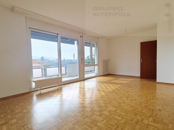 / an empty room with wooden floors and large windows