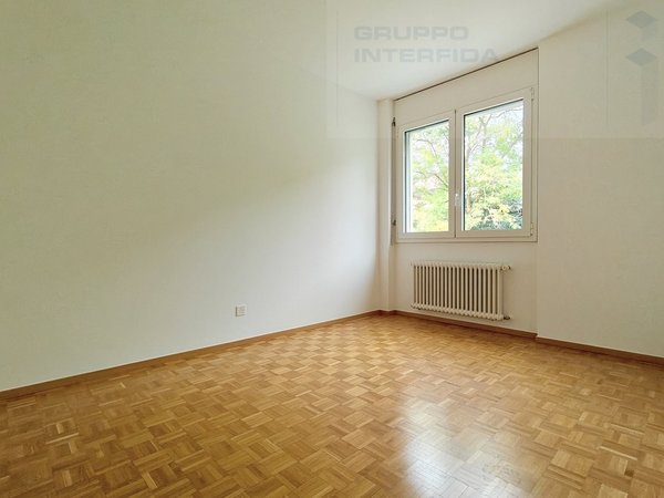 / an empty room with white walls and a large window