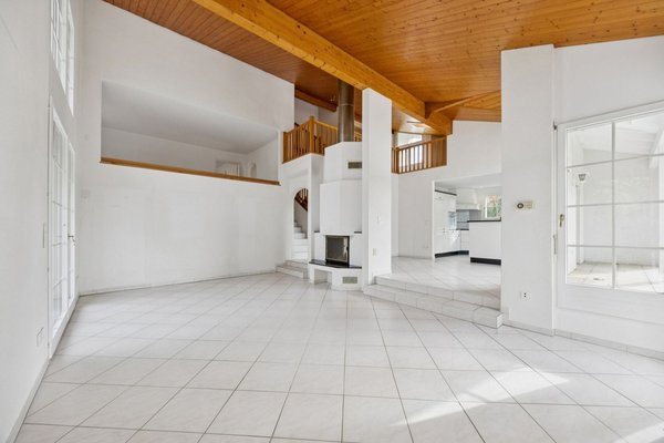 Offenes Wohn- und Esszimmer mit Cheminée und Blick ins Galeriezimmer