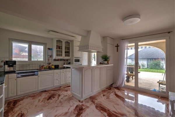 Die moderne Küche mit zwei Ausängen zum Garten