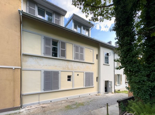 Façade entrée Nord, 2 places parc voitures privées, abri couvert pour vélo, porte entrée appartements et cave buanderie dans impasse