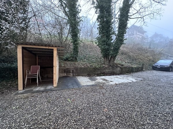 Façade entrée Nord, 2 places parc voitures privées, abri couvert pour vélo, porte entrée appartements et cave buanderie dans impasse