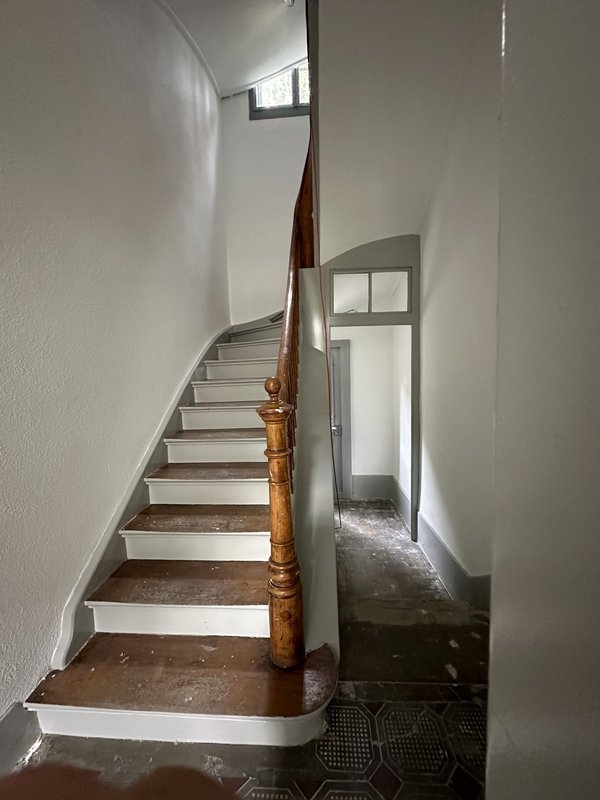 Cage escaliers en chêne origine, dalles ciment, vue sur entrée secondaire Nord : 2 places de parc voiture privée, abri couvert pour vélo, descente cave et buanderie