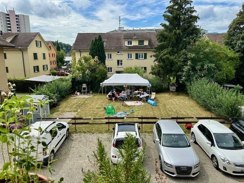 Aussicht auf den Parkplatz und Gemeinschaftsgarten inkl. Cheminée hinter dem Haus