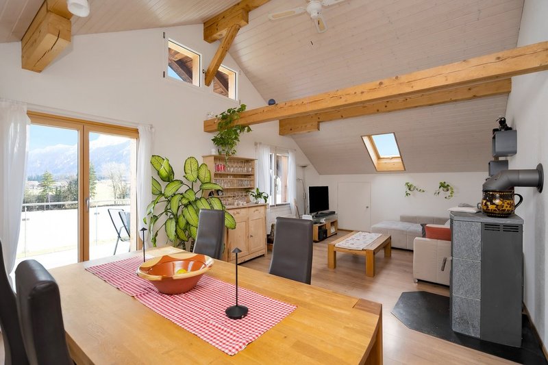 Wohnbereich mit Parkettboden, Schwedenofen und direktem Ausgang zum Balkon mit Südausrichtung