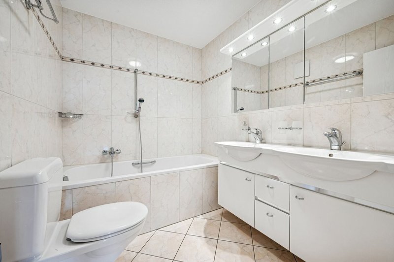 Badezimmer mit Doppelwaschbecken und Badewanne