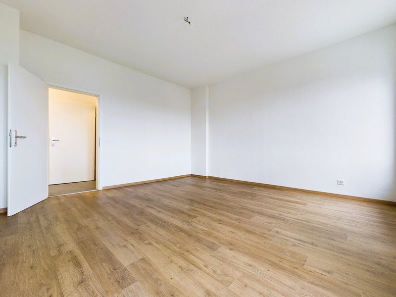 / an empty room with white walls and wooden floors and a sliding door
