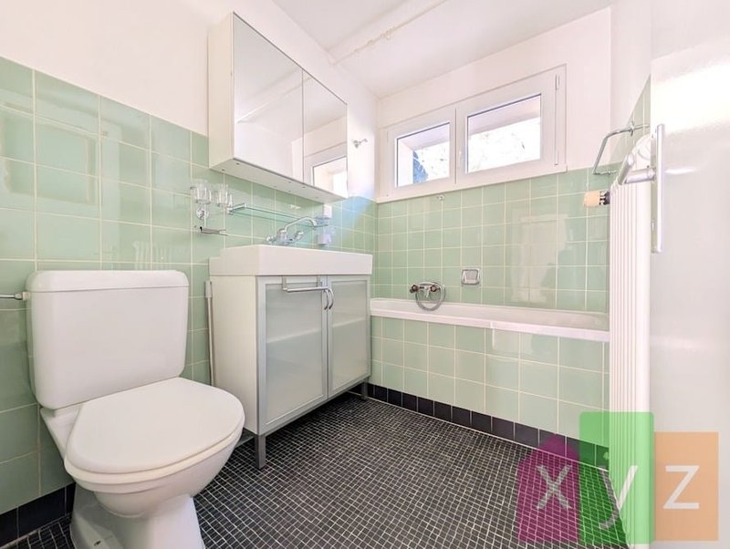 La salle de bain équipée d'une baignoire et d'une fenêtre