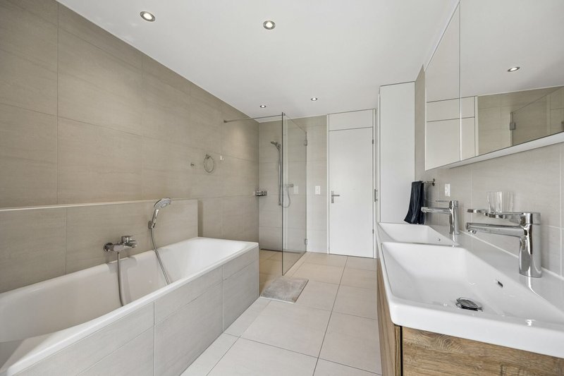 Badezimmer mit Dusche, Badewanne und Doppelwaschbecken